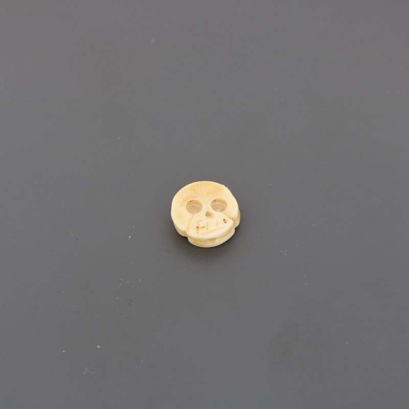 Componente osso beige tondo piatto con inciso teschio 12 mm 1pz