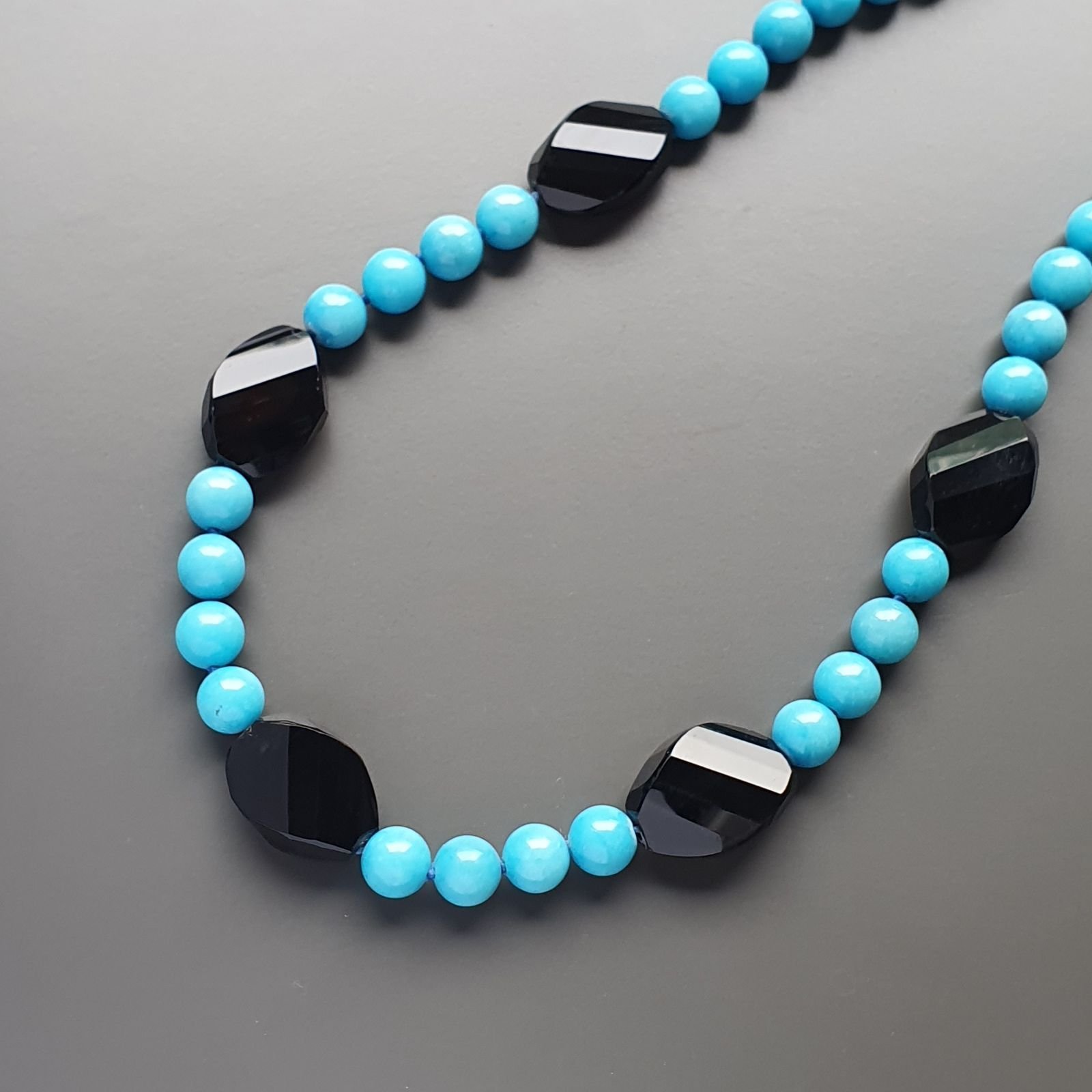 Collana girocollo aulite azzurra sferico liscio 10mm con onice nera ovale schiacciato twist 25x18mm annodato