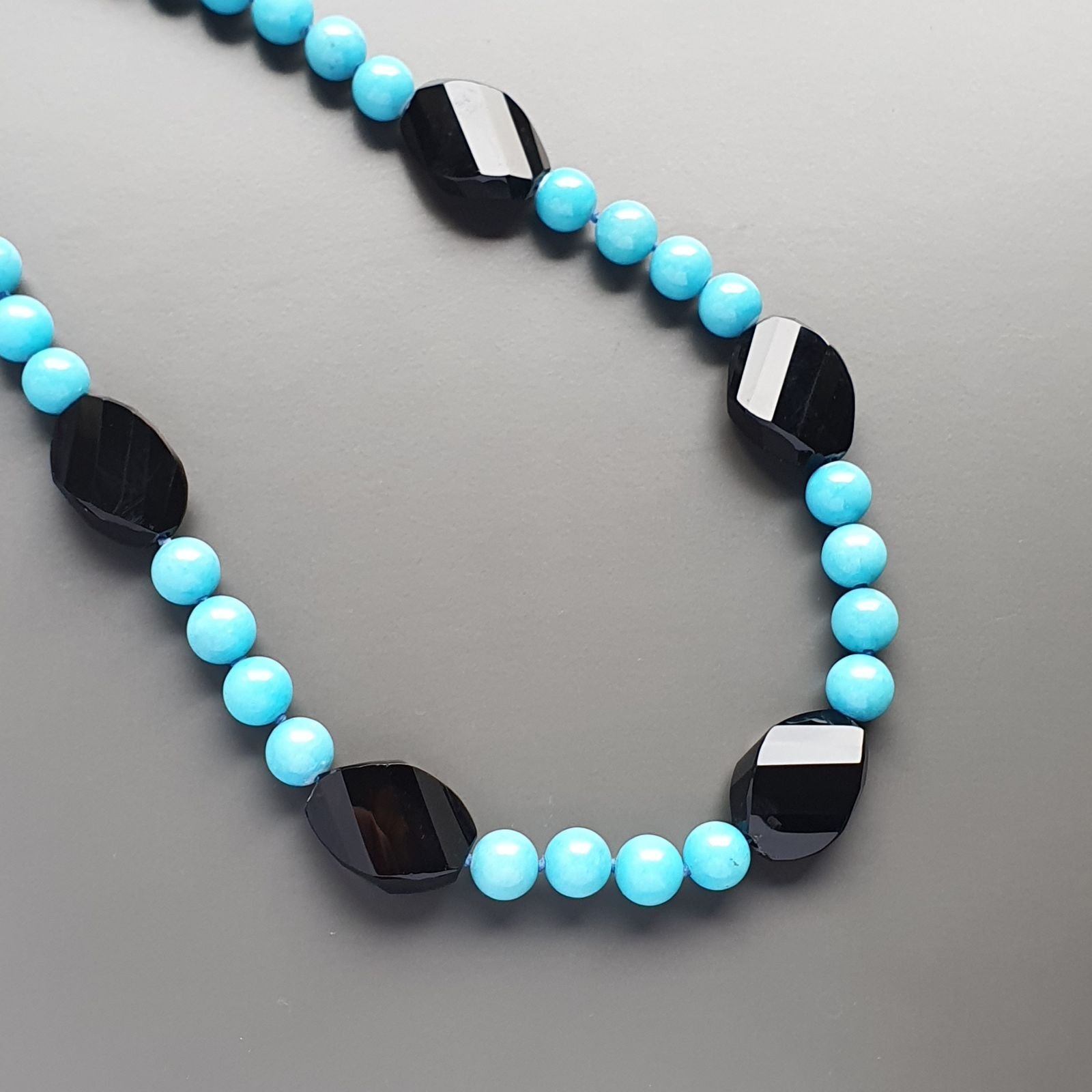Collana girocollo aulite azzurra sferico liscio 10mm con onice nera ovale schiacciato twist 25x18mm annodato