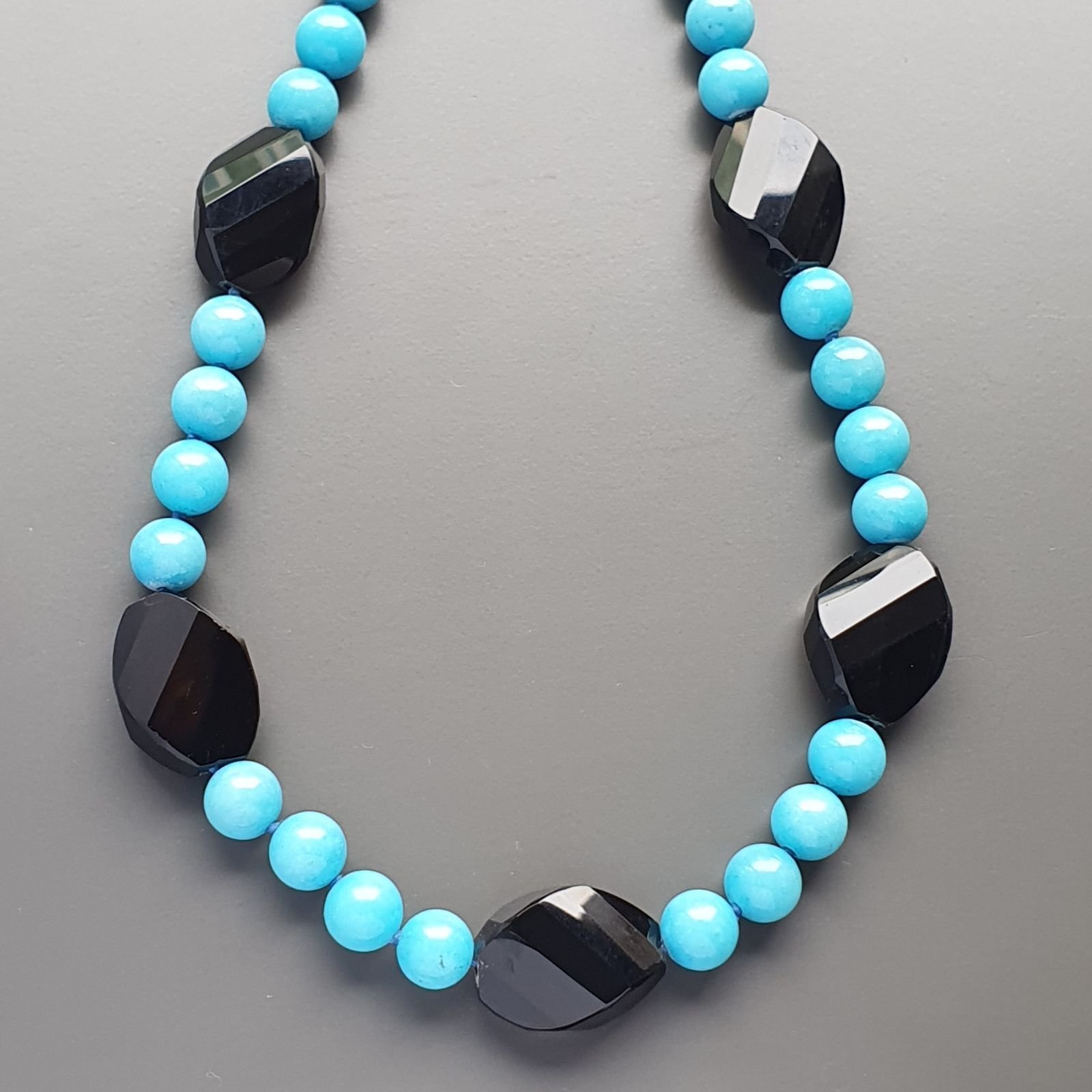 Collana girocollo aulite azzurra sferico liscio 10mm con onice nera ovale schiacciato twist 25x18mm annodato